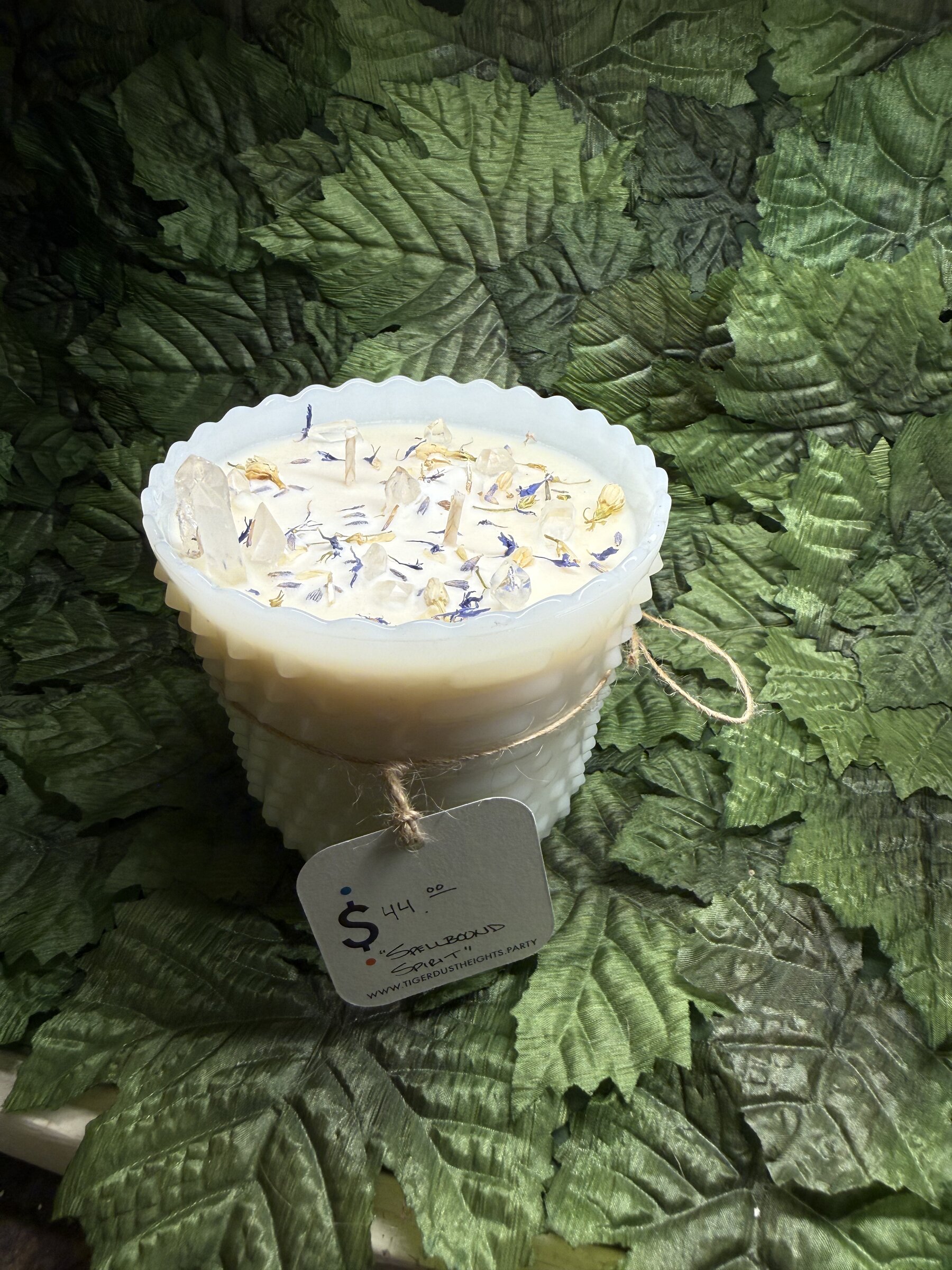 Hand-poured candle on a leaf backdrop